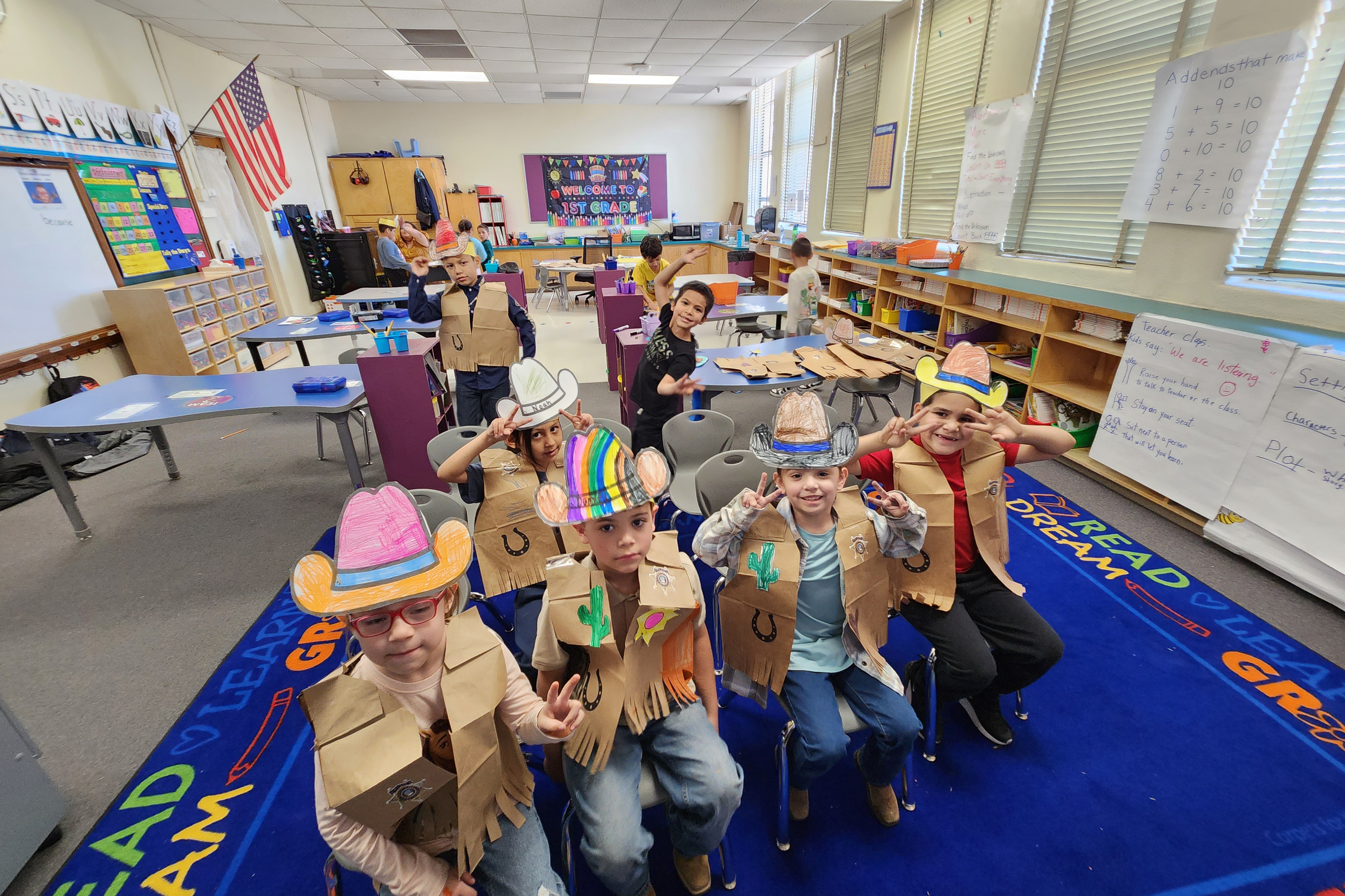 Students show off the vests and cowboy hats they made in class