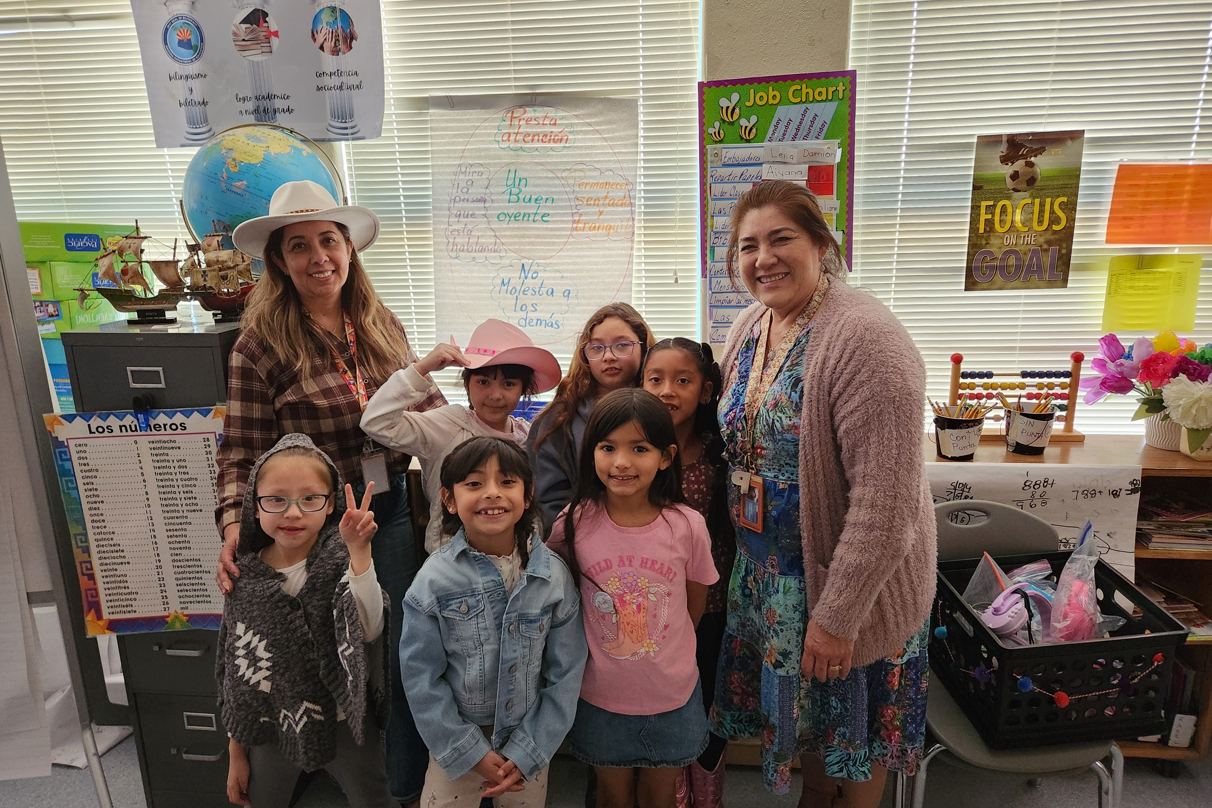 Two teachers and several of their students show off their western outfits