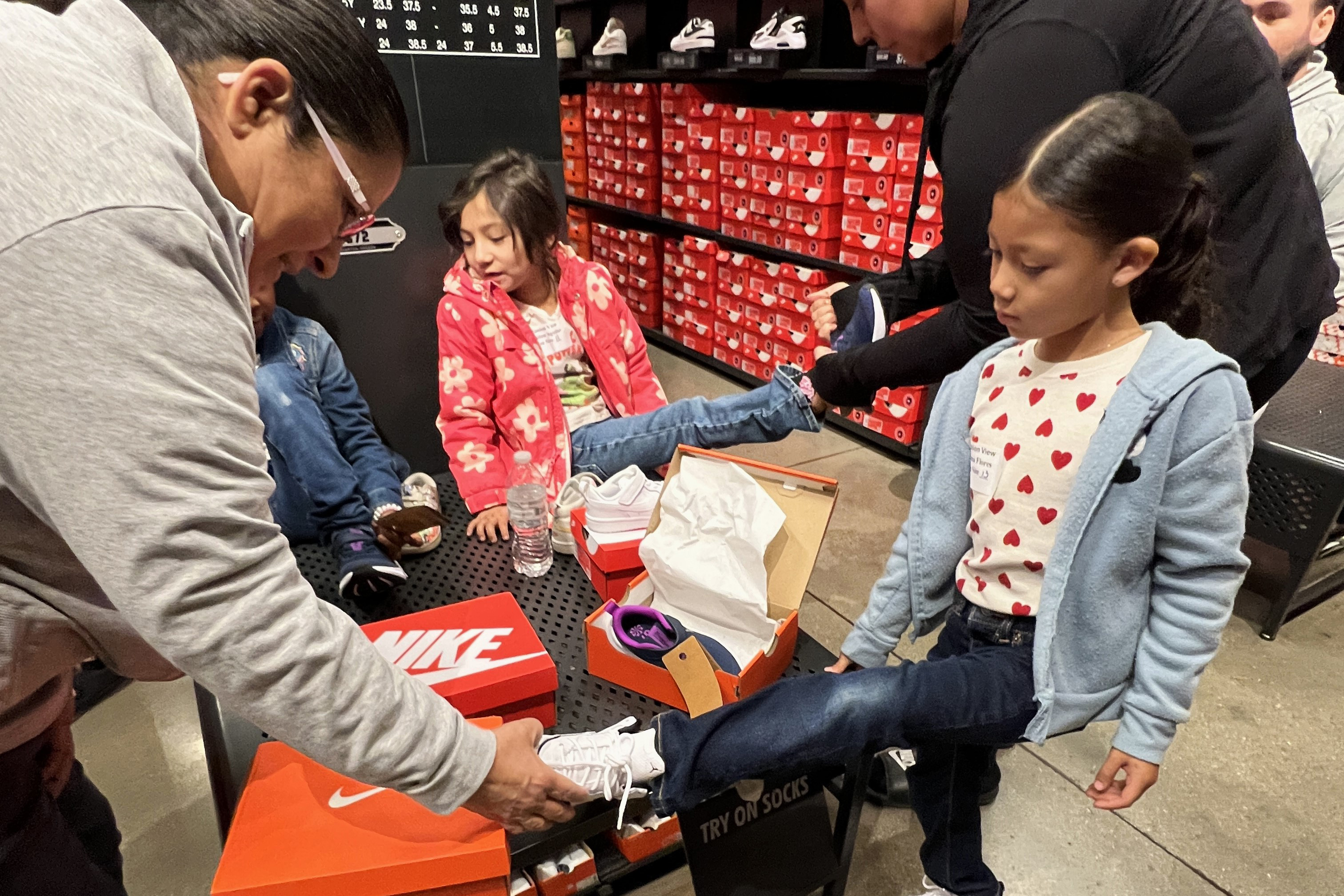 A man helps a girl try on a pair of shoes