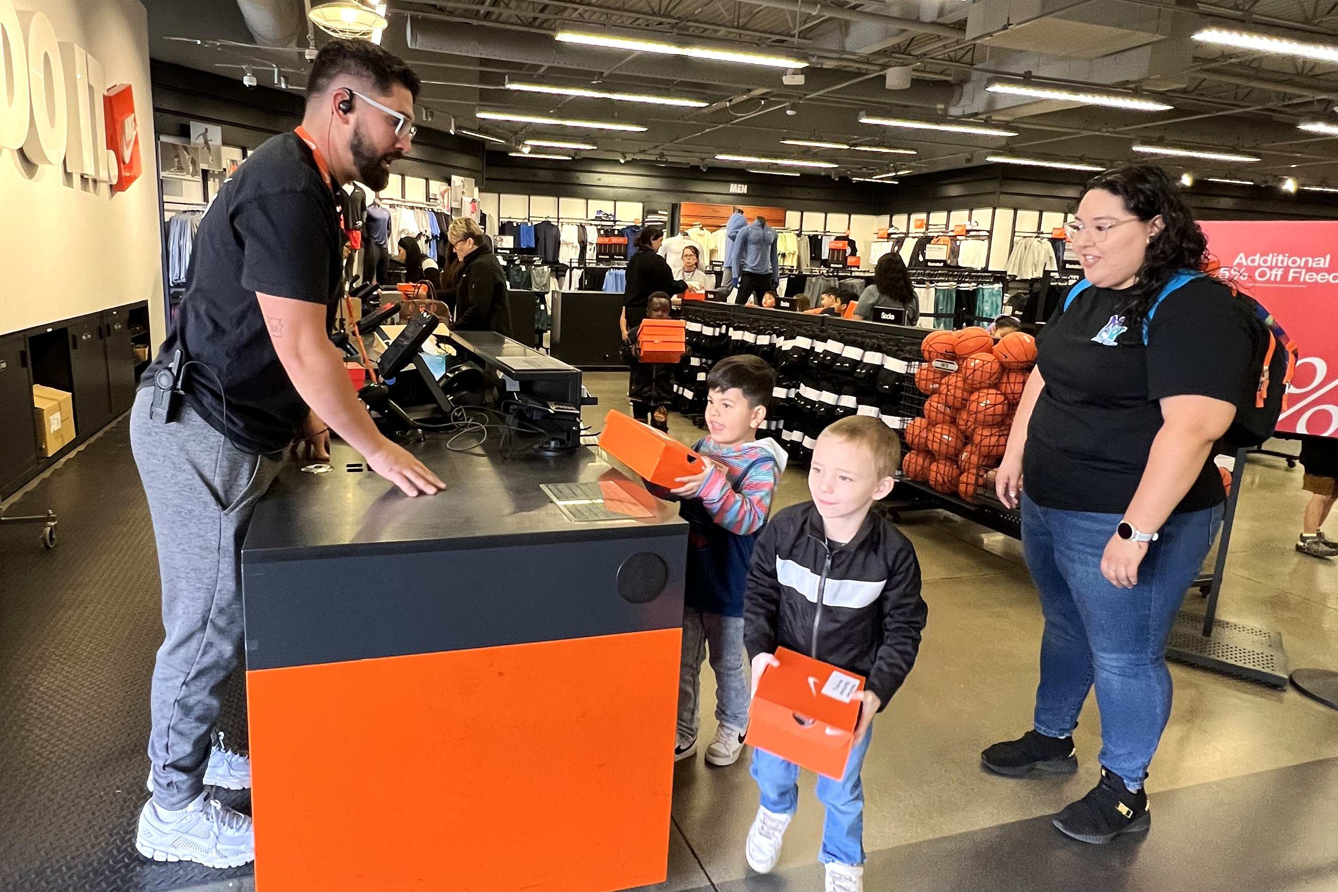 Two boys bring their new shoes to the cash register