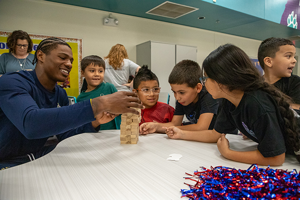 A man plays Jenga with some students
