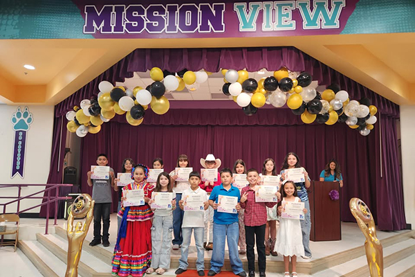 Students on stage with their mariachi certificates