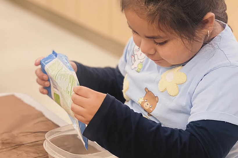 A girl pours flour into a bowl