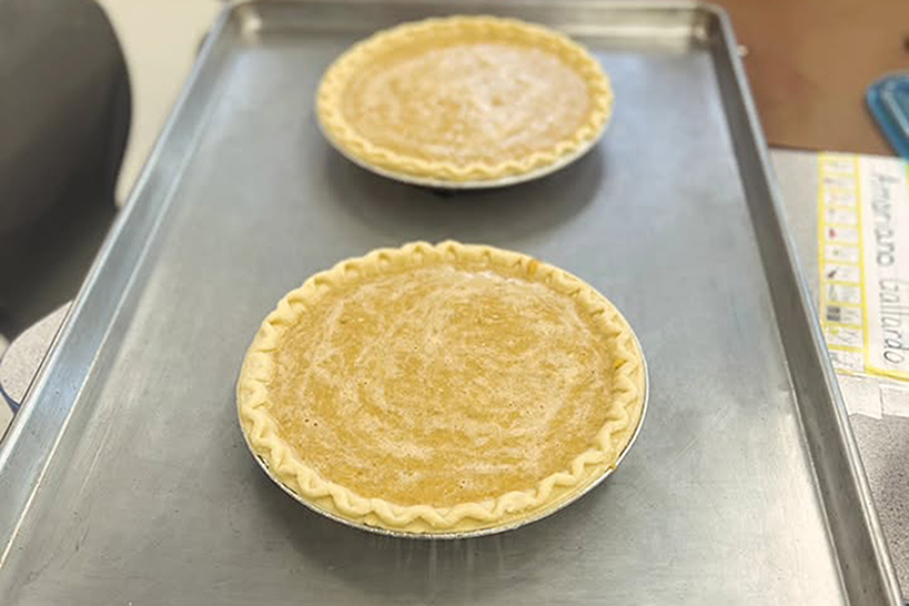 Two pumpkin pies on a baking sheet