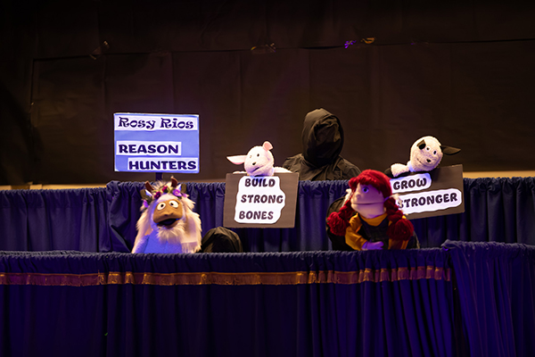 Puppets hold up signs reading Rosy Rios Reason Hunters, Build Strong Bones and Grow Stronger