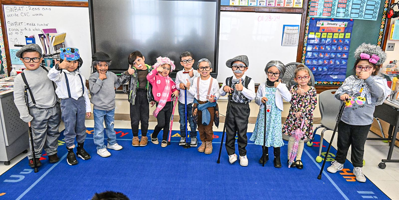 Ms. Lopez's kindergarten class poses for a photo dressed as 100 year olds for the 100th day of school