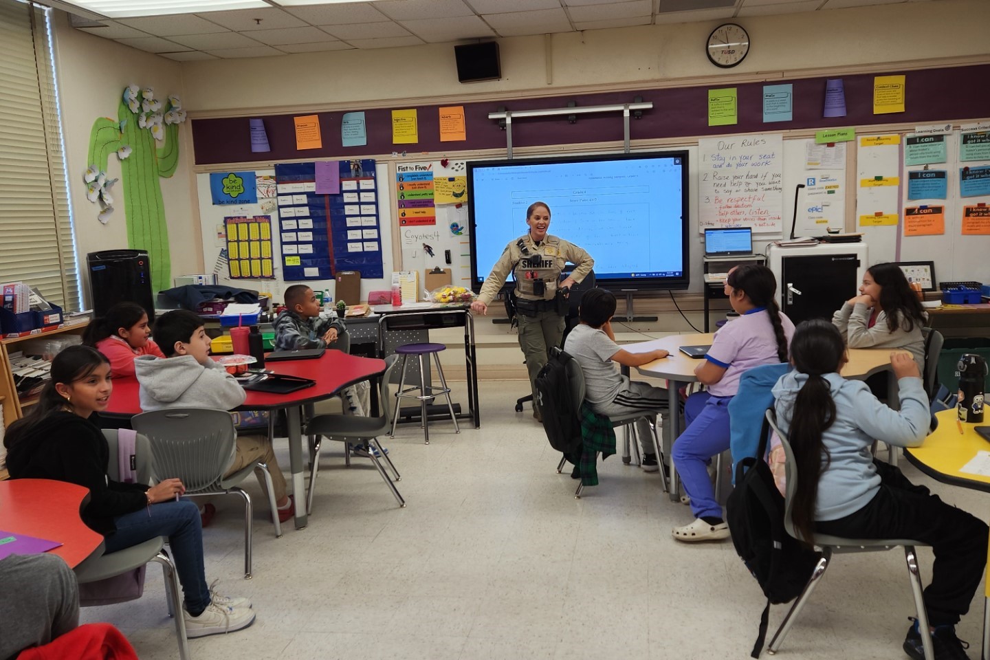 A TUSD Student Resource Officer reads to a classroom of students