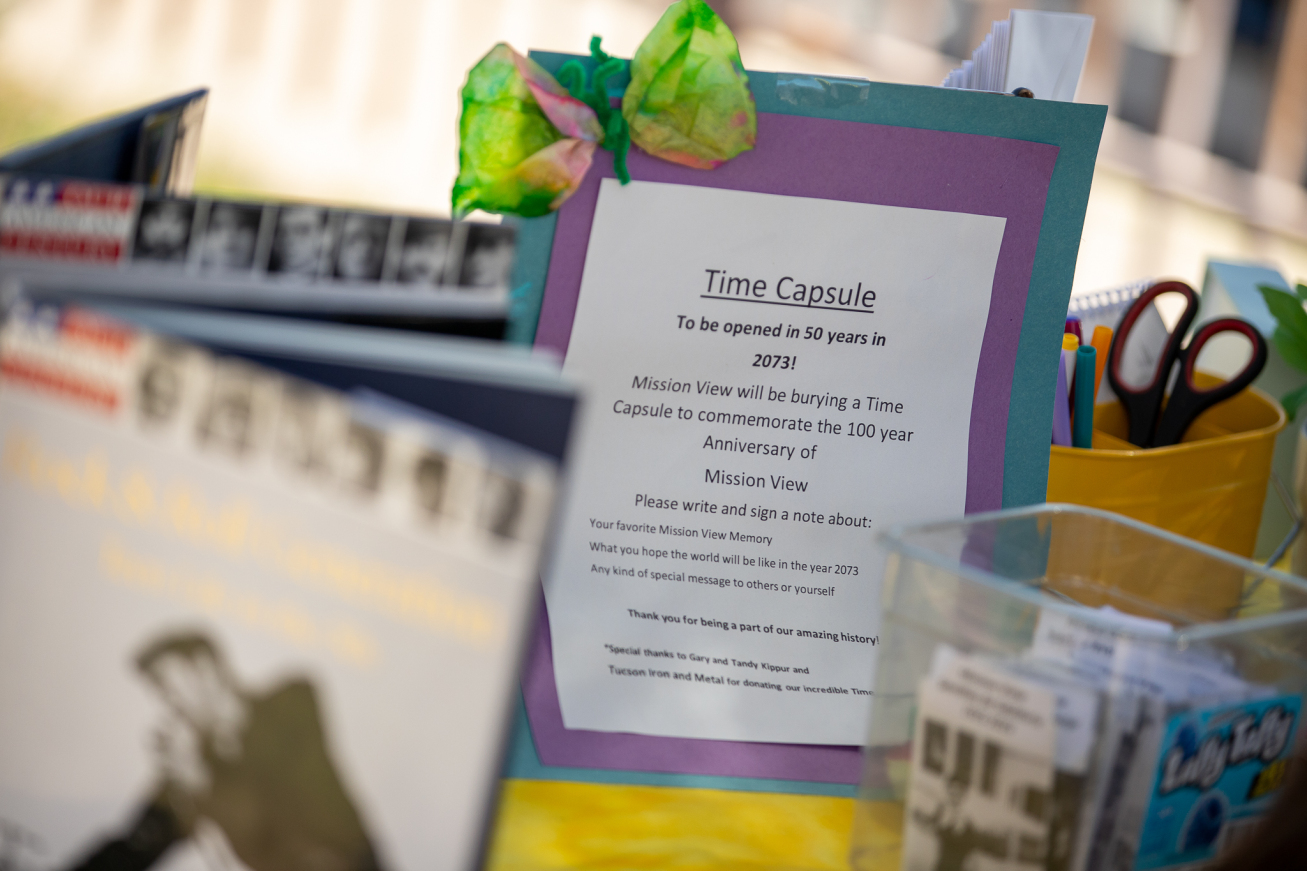 A sign explaining the time capsule is on a table with other artifacts from the school's history